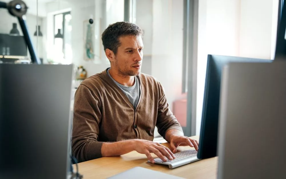 Man werkt aan computer in moderne werkomgeving – digitale ondernemer