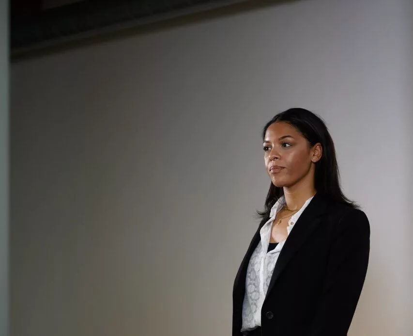 Zakenvrouw in kostuum poseert zelfverzekerd in een moderne kantoorruimte