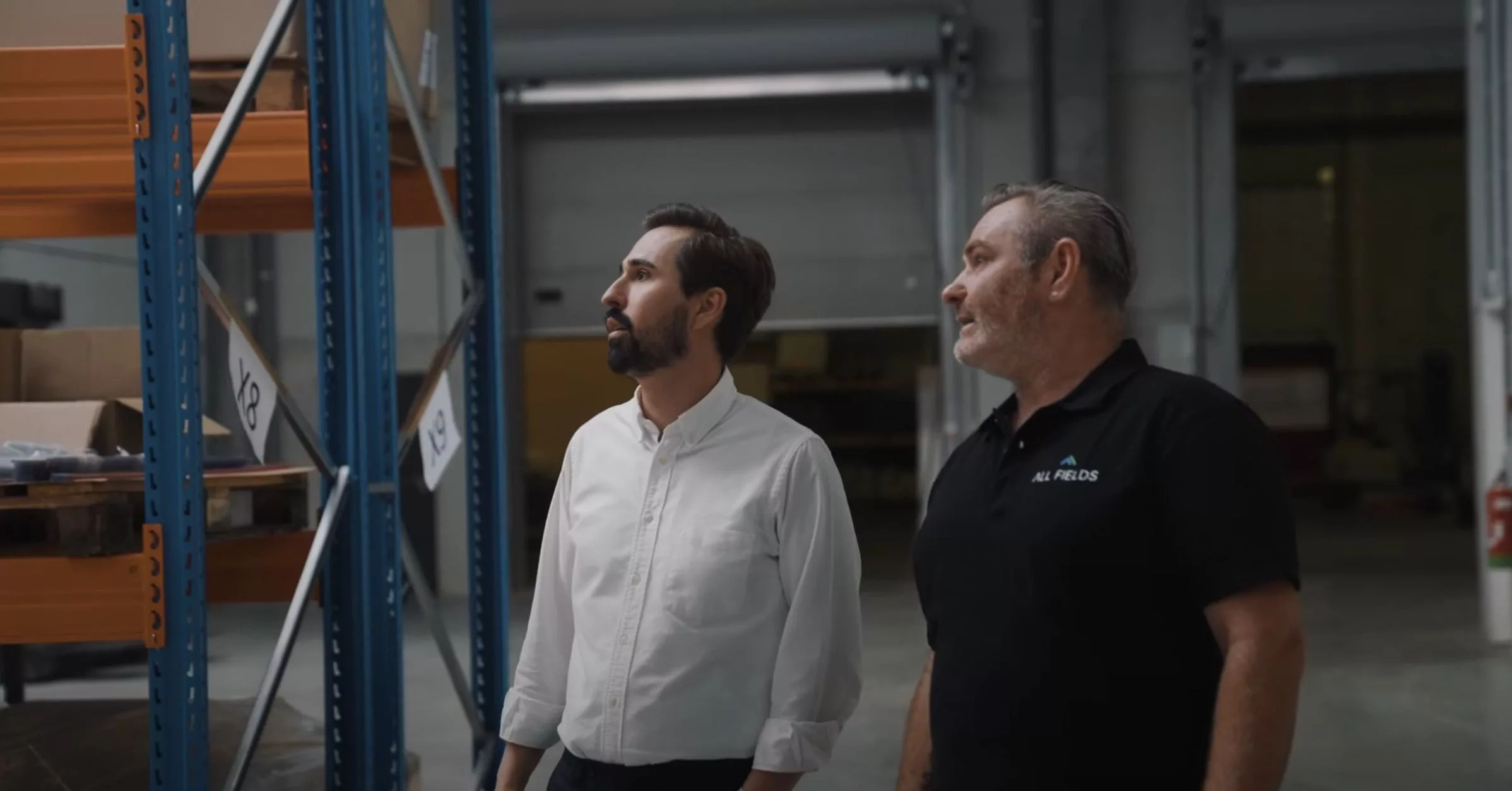 Twee mannen in magazijnomgeving tijdens bedrijfsbezoek bij All Fields